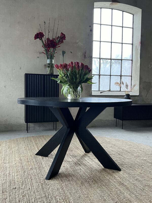 Alta- Round dining table with a stylish base and a durable design on which the table top rests. Veneered black stained oak. Insert plate 45cm x 2pcs. Height 76 cm.